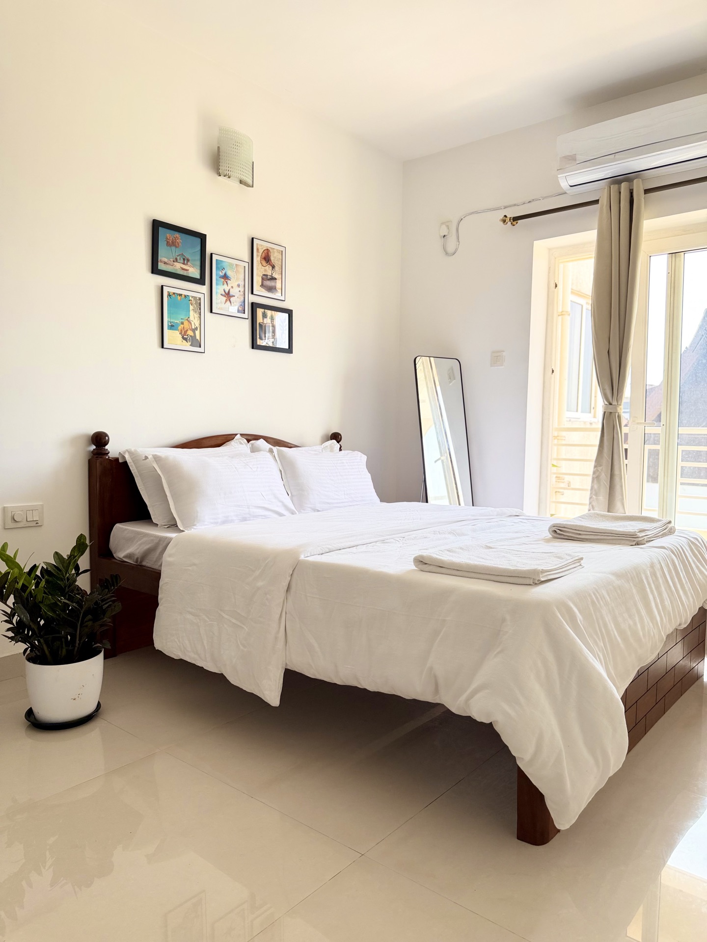 Bedroom with queen bed, AC, and gallery wall