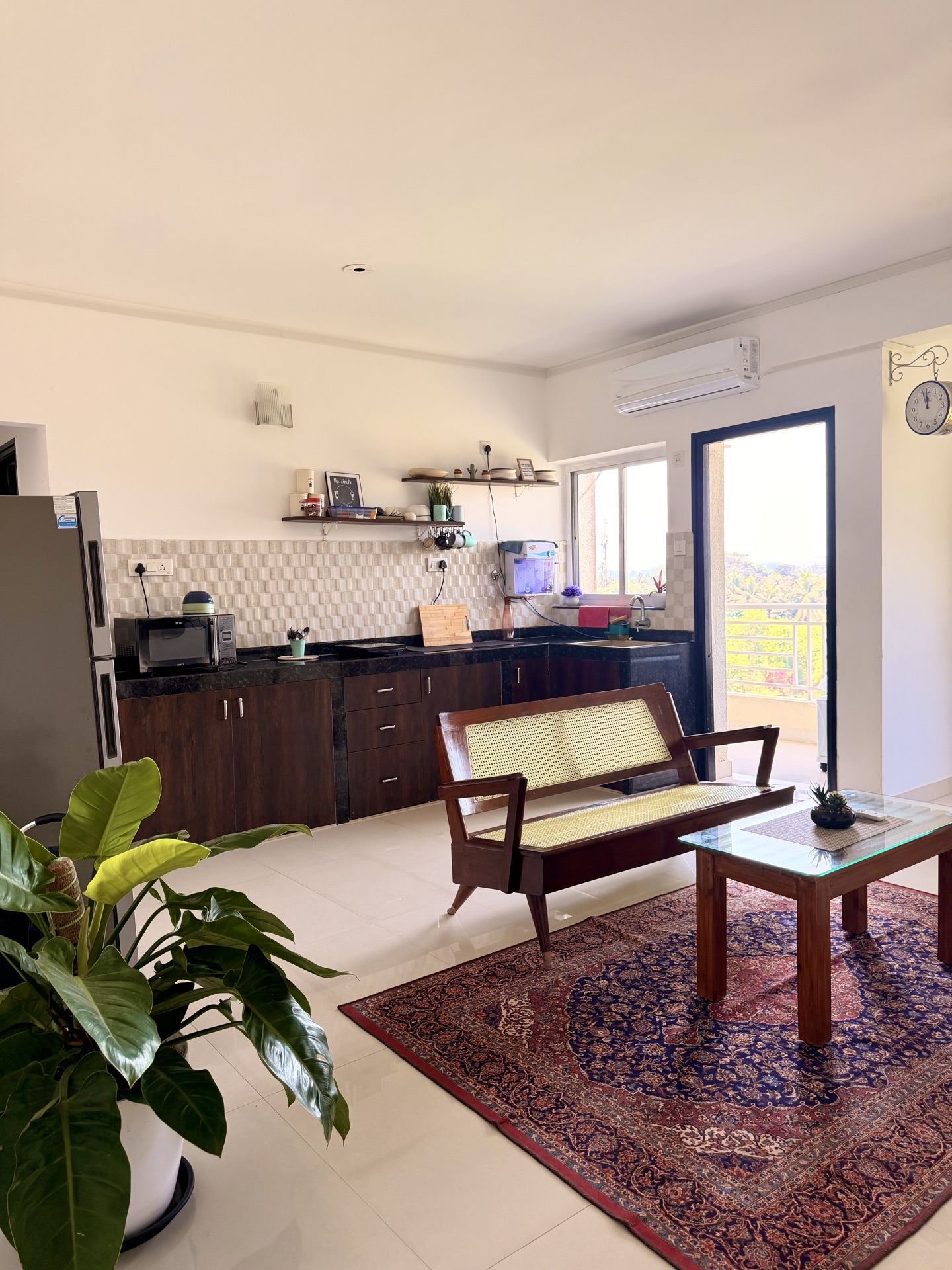 Spacious living room with kitchen and greenery views