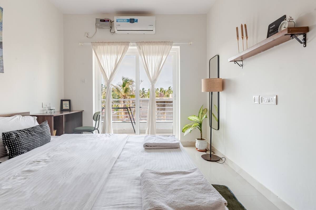 Bedroom with balcony access and palm tree views