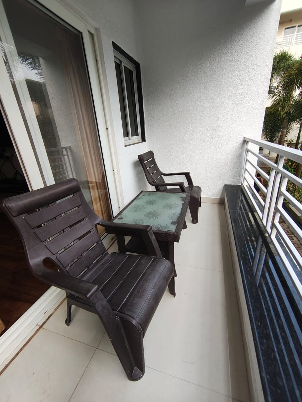 Long side balcony with lounger chairs and bistro table