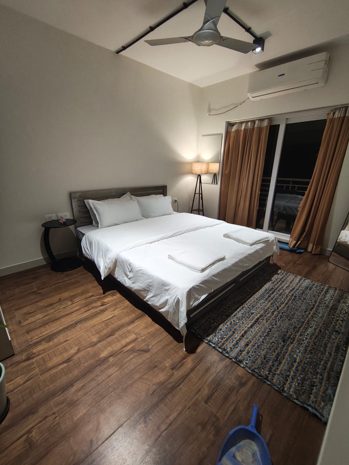 Bedroom with king bed, ceiling fan, and tripod floor lamp
